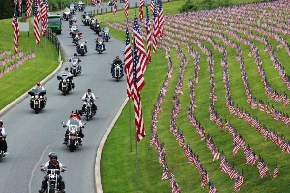 In this May 27, 2017 photo, motorcyclists ride into Indiantown Gap National Cemetery in Annville, Pa., for a Memorial Day weekend program. While millions of Americans celebrate the long Memorial Day weekend as the unofficial start of summer, some veterans and loved ones of fallen military members wish the holiday that honors the nation’s war dead would command more respect. (AP Photo/Michael Rubinkam)