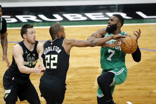 Milwaukee Bucks' Khris Middleton (22) hits the ball away from Boston Celtics' Jaylen Brown (7) during the second half of an NBA basketball game Friday, March 26, 2021, in Milwaukee. (AP Photo/Aaron Gash)