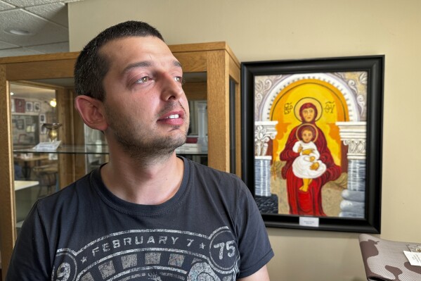 Dmytro Haiman looks out the window from the Ukrainian Cultural Institute in Dickinson, N.D., on Monday, July 17, 2023. Haiman is one of several Ukrainians who are part of a pilot effort of the North Dakota Petroleum Council's Bakken Global Recruitment of Oilfield Workers program. Haiman is from Chernihiv, Ukraine. (AP Photo/Jack Dura)