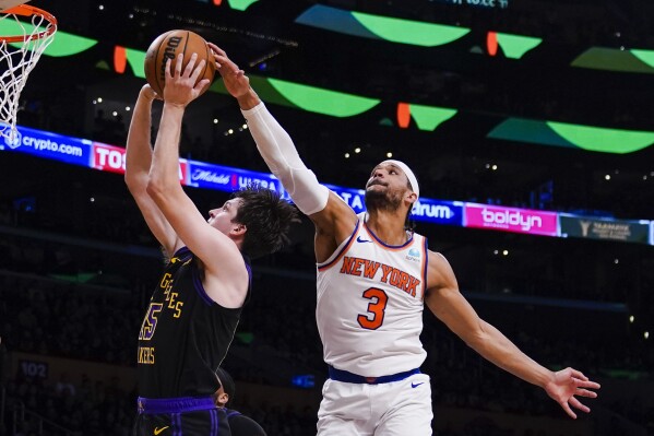 New York Knicks guard Josh Hart (3) blocks a shot-attempt by Los Angeles Lakers guard Austin Reaves, left, during the first half of an NBA basketball game, Monday, Dec. 18, 2023, in Los Angeles. (AP Photo/Ryan Sun)