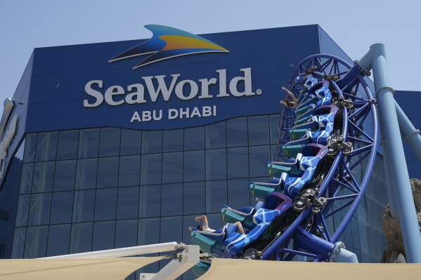People enjoy riding on a roller coaster at the SeaWorld on Yas Island in Abu Dhabi, United Arab Emirates, on May 26, 2023. It’s the first venture outside the United States for the theme park chain, which had been mired in controversy in recent years over the treatment of captive killer whales. The $1.2 billion Abu Dhabi venture with state-owned developer Miral features the world's largest aquarium and cylindrical LED screen, as well as state-of-the-art facilities housing dolphins, seals, and other animals. (AP Photo/Nick ElHajj)