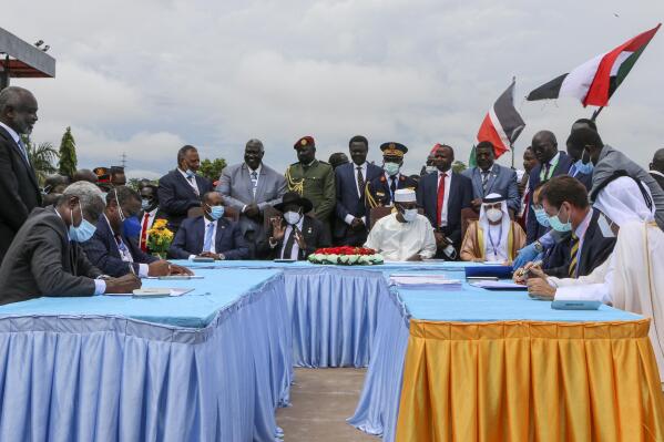 FILE - The then head of Sudan's sovereign council, Gen. Abdel-Fattah Burhan, seated center-left, President of South Sudan Salva Kiir, seated center, and then President of Chad Idriss Deby, seated center-right, attend a ceremony to sign a peace deal between Sudan's transitional authorities and a rebel alliance, in Juba, South Sudan, on Oct. 3, 2020.  In a report to the U.N. Security Council circulated Friday, Feb. 4, 2022, its experts say rebel groups in Darfur that signed a peace agreement with the Sudanese government in 2020 continue to operate in Libya and profit from opportunities provided by the civil war and lack of government control in the oil-rich north African nation.  (AP Photo/Maura Ajak, File)