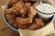 FILE - Party chicken wings with cilantro sour cream dip and honey sriracha are displayed in Concord, N.H., on Nov. 16, 2015. Preparing and keeping foods at the right temperature, avoiding cross contamination -- no double dipping! -- and being mindful about leaving out perishable snacks like chicken wings, meatballs and veggie platters are all keys to avoiding illness at your Super Bowl party, health experts said. (AP Photo/Matthew Mead, File)