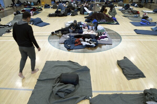 FILE - Migrants rest at a makeshift shelter in Denver, Jan. 6, 2023. Five mayors from around the U.S. want a meeting with President Joe Biden to ask for help controlling the continued arrival of large groups of migrants to their cities. The mayors of Denver, Chicago, Houston, New York and Los Angeles say in a letter to Biden that there has been little to no coordination, support or resources and that is leading to a crisis. (AP Photo/Thomas Peipert)