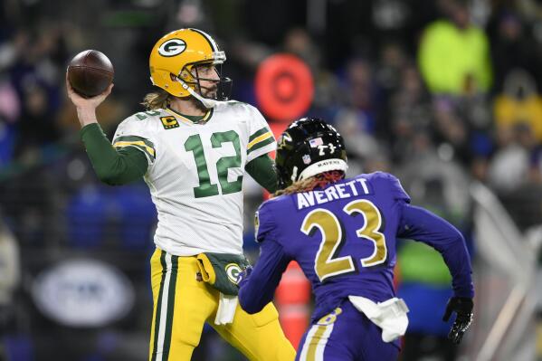 Green Bay Packers quarterback Aaron Rodgers (12) throws to a receiver as he is pressured by Baltimore Ravens cornerback Anthony Averett in the first half of an NFL football game, Sunday, Dec. 19, 2021, in Baltimore. (AP Photo/Nick Wass)