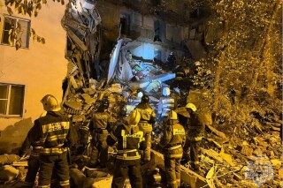 In this photo released by Russian Emergency Ministry Press Service on Thursday, Nov. 16, 2023, Russian Emergency Ministry work at the side of a five-storey building partially collapsed in Astrakhan, Russia. Part of a residential building has collapsed in southern Russia, killing one woman and sparking a search and rescue operation, Russian state news agency Tass said. Before part of the building in the southern city of Astrakhan collapsed, the Ministry of Emergency Situations said it had received information about cracks appearing. (Russian Emergency Ministry Press Service via AP)
