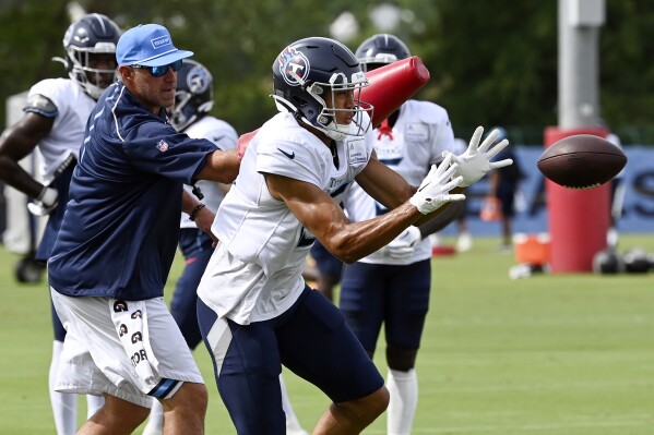 FILE - Tennessee Titans wide receiver Treylon Burks makes a catch as head coach Mike Vrabel hits him with an arm pad during an NFL football training camp practice, Aug. 8, 2023, in Nashville, Tenn. The Titans have avoided a major injury after Burks injured his left knee on Wednesday, Aug. 16. Coach Vrabel said Thursday that Burks suffered no structural damage. (Mark Zaleski/The Tennessean via AP, File)