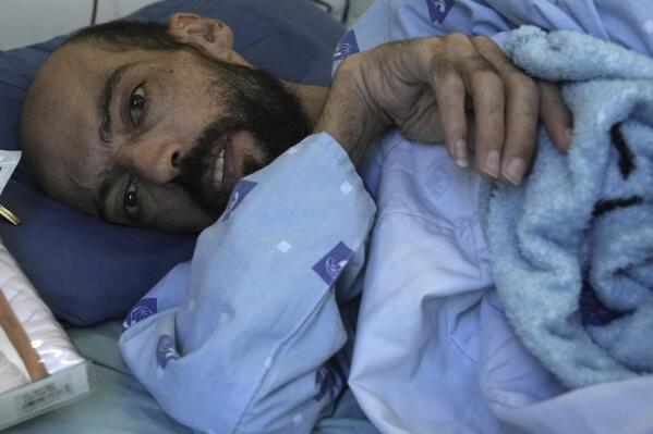 FILE - Khalil Awawdeh, a Palestinian who has been on a hunger strike for several months protesting being jailed without charge or trial under what Israel refers to as administrative detention, lies in bed at Asaf Harofeh Hospital in Be'er Ya'akov, Israel, Wednesday, Aug. 24, 2022.  Awawdeh, a Palestinian detainee held without charge or trial by Israel will suspend his nearly six-month hunger strike after receiving a “written agreement” that he will be released in October, Palestinian officials said Wednesday, Aug. 31.  (AP Photo/ Mahmoud Illean, File)