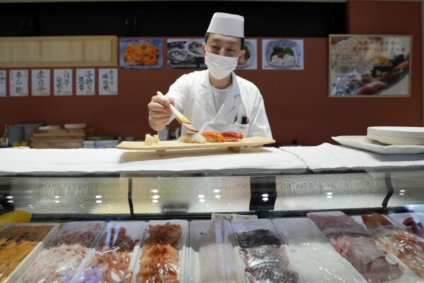 FILE - A sushi chef prepares a plate at the Toyosu Market Monday, Jan. 29, 2024, in Tokyo. Japan has slipped to the world’s fourth-largest economy as government data released Thursday, Feb. 14, 2024, showed it fell behind the size of Germany's in 2023. (AP Photo/Eugene Hoshiko, File)