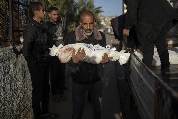 Palestínsky muž nesie telo svojho vnuka, ktorý bol umučený pri izraelskom bombardovaní pásma Gazy, v nemocnici Rafah, južne od Gazy, piatok 22. decembra 2023. (AP Photo/Fatima Shbair)