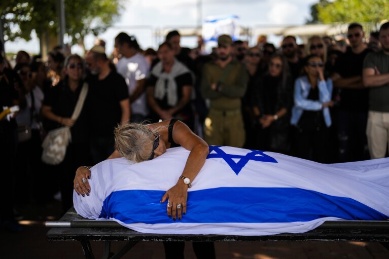 FILE - Antonio Macías' mother cries over her son's body covered with the Israeli flag at Pardes Haim cemetery in Kfar Saba, near Tel Aviv, Israel on Oct. 15, 2023. Macias was killed by Hamas militants while attending a music festival in southern Israel. (AP Photo/Francisco Seco, File)