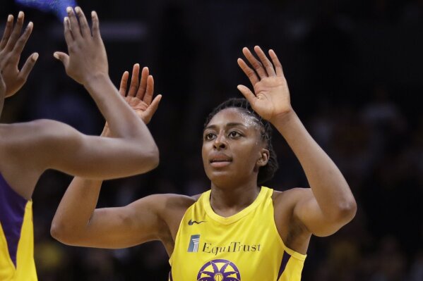 FILE - In this Friday, May 31, 2019, file photo, Los Angeles Sparks' Chiney Ogwumike (13), obscured at left, and her sister Nneka Ogwumike celebrate after a win over the Connecticut Sun in a WNBA basketball game in Los Angeles. The WNBA and its union announced a tentative eight-year labor deal Tuesday, Jan. 14, 2020,  that will allow top players to earn more than $500,000 while the average annual compensation for players will surpass six figures for the first time. “It was collaborative effort,'" WNBA players' union president Nneka Ogwumike said.  (AP Photo/Marcio Jose Sanchez, File)