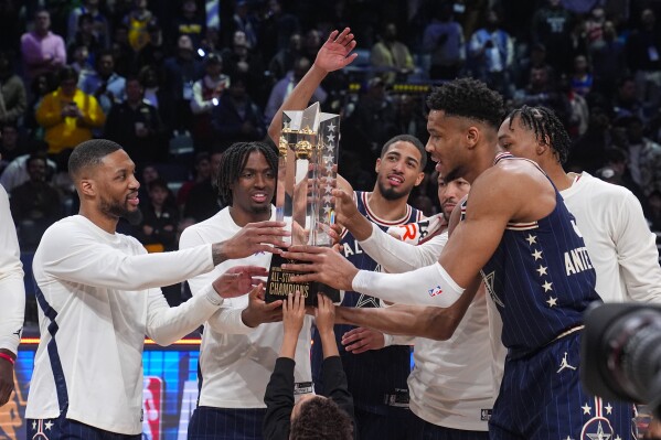 The East team, lead by captain Milwaukee Bucks forward Giannis Antetokounmpo, right, hoists the trophy after defeating the West 211-186 in the NBA All-Star basketball game in Indianapolis, Sunday, Feb. 18, 2024. (APPhoto/Darron Cummings)