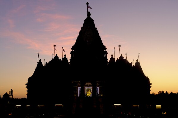 The sun sets at the BAPS Swaminarayan Akshardham, the largest Hindu temple outside India in the modern era, on Wednesday Oct. 4, 2023, in Robbinsville, N.J. The temple was partly built using marble from Italy and limestone from Bulgaria hand-carved by artisans in India and shipped to New Jersey. (AP Photo/Luis Andres Henao)