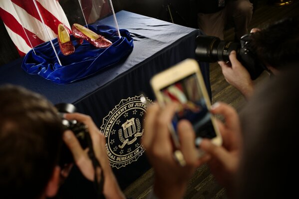 
              A pair of ruby slippers once worn by actress Judy Garland in the "The Wizard of Oz" are displayed at a news conference Tuesday, Sept. 4, 2018, at the FBI office in Brooklyn Center, Minn. Authorities announced that the slippers, stolen in 2005 from the Judy Garland Museum in Grand Rapids, Minn., were recovered in a sting operation. The FBI says it has multiple suspects in the extortion and that the investigation continues. Four pairs of ruby slippers worn by Garland in the movie are known to exist. (Richard Tsong-Taatarii/Star Tribune via AP)
            