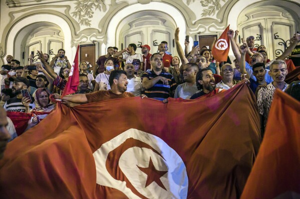 Tunisians celebrate the exit polls indicating a vote in favor of the new Constitution, in Tunis, on July 25, 2022. (AP Photo/Riadh Dridi, File)