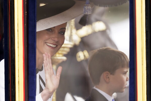 Kate, Princess of Wales waves to the crowd, with her youngest son Prince Louis of Wales alongside her as they travel along the Mall to attend the Trooping the Color ceremony, in London, Saturday, June 15, 2024. Trooping the Color is the King's Birthday Parade and one of the nation's most impressive and iconic annual events attended by almost every member of the Royal Family. (AP Photo/Alberto Pezzali)