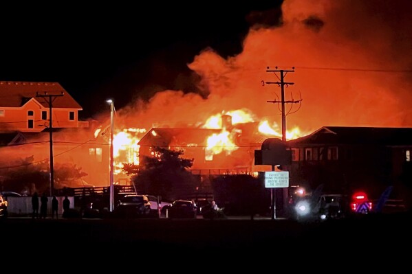 An oceanfront rental house is engulfed in fire, Friday, Aug. 11, 2023 in Kill Devil Hills, N.C. Mulitple people thought to be vacationing in North Carolina's Outer Banks died early Friday morning in a fatal house fire, city officials said Friday.(Kari Pugh/The Virginian-Pilot via AP)