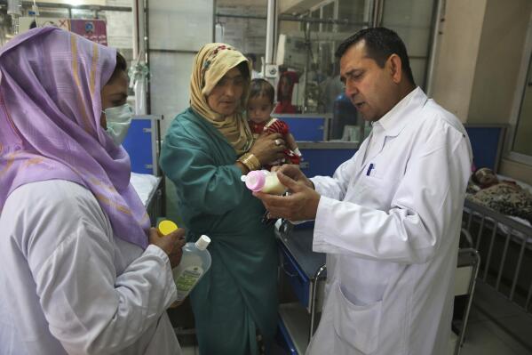 FILE - In this Aug. 21, 2019 file photo, a doctor briefs the mother of a malnourished child on how to feed her baby in a ward at Indira Gandhi hospital in Kabul, Afghanistan. After nearly 20 years since the ouster of the Taliban and hundreds of millions of dollars spent on infrastructure and aid, many Afghan women still have poor access to health facilities and providers, Human Rights Watch said Thursday, May 6, 2021 in its latest report. (AP Photo/Rafiq Maqbool, File)