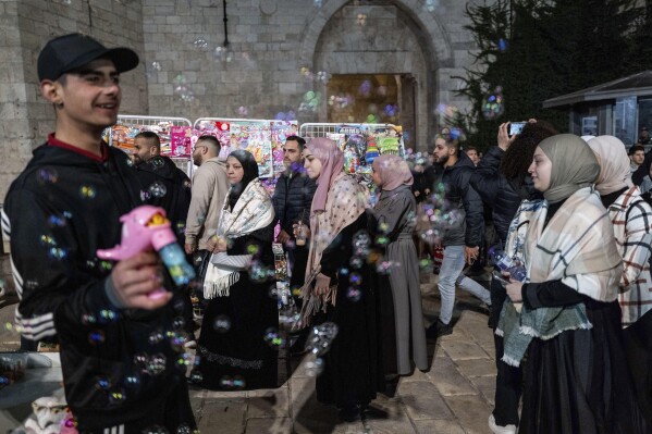 People walk in front of the Damascus gate in the Old City of Jerusalem, on the first day of Ramadan, Monday, March 11, 2024. (AP Photo/Ohad Zwigenberg)