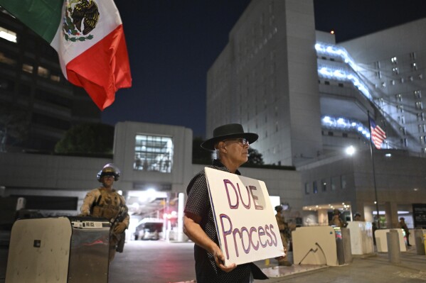 A protester stands outside the Metropolitan Detention Center Tuesday, June 17, 2025, in Los Angeles. (AP Photo/Wally Skalij)