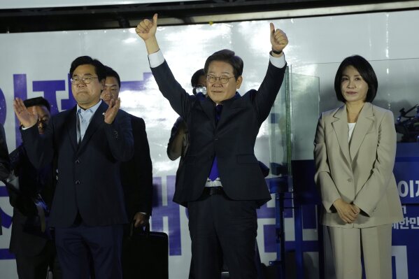 South Korea's Democratic Party's presidential candidate Lee Jae-myung, center, and his wife Kim Hea Kyung, right, greet supporters outside of the National Assembly in Seoul, South Korea, Wednesday, June 4, 2025. (AP Photo/Ahn Young-joon)