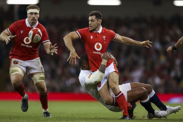 Wales' Tomos Williams, center, offloads to Aaron Wainwright during the Summer Nations Series match at the Principality Stadium, Cardiff, Wales, Saturday, Aug. 5, 2023. (Ben Whitley/PA via AP)