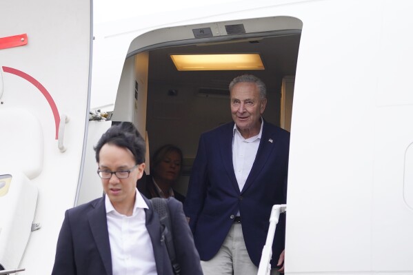 U.S. Senate Majority Leader Chuck Schumer, D-N.Y., right, and other members of the delegation arrive at Shanghai Pudong International Airport in Shanghai, China, Saturday, Oct. 7, 2023. (Aly Song/Pool Photo via AP)
