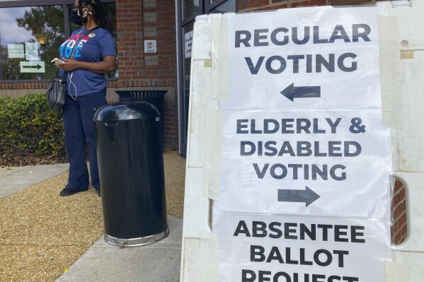 FILE - Signs to guide voters are posted outside a Cobb County polling station on the first day of early voting, in Marietta, Ga., Oct. 17, 2022. (AP Photo/Mike Stewart, File)