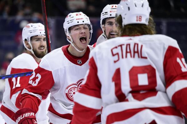 Detroit Red Wings' Lucas Raymond, second from left, celebrates with Dylan Larkin (71) and Marc Staal (18) after scoring a goal during the first period of an NHL hockey game against the Philadelphia Flyers, Wednesday, Feb. 9, 2022, in Philadelphia. (AP Photo/Derik Hamilton)
