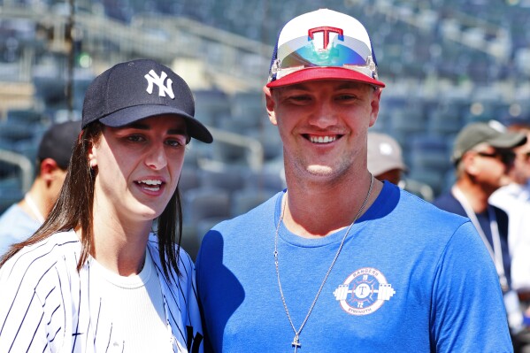 WNBA basketball player Caitlin Clark and Texas Rangers Josh Jung are photographed before a baseball double header game between the New York Yankees and the Texas Rangers, Saturday, Aug. 10, 2024 in New York. (AP Photo/Noah K. Murray)