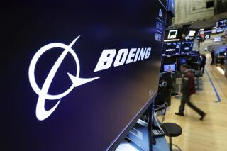 FILE - In this March 11, 2019 file photo, the Boeing logo appears above a trading post on the floor of the New York Stock Exchange before the opening bell. Boeing is suing a subcontractor it hired to work on new Air Force One planes that will carry the president of the United States. Boeing says a subcontractor on in Fort Worth, Texas, missed deadlines for work on the planes. (AP Photo/Richard Drew, File)