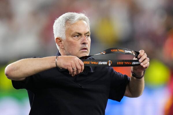 Roma's head coach Jose Mourinho takes off his second place medal after receiving it at the end of the Europa League final soccer match between Sevilla and Roma, at the Puskas Arena in Budapest, Hungary, Wednesday, May 31, 2023. Sevilla defeated Roma 4-1 in a penalty shootout after the match ended tied 1-1. (AP Photo/Petr David Josek)