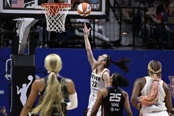 Indiana Fever guard Caitlin Clark (22) scores her first basket against the Connecticut Sun during the second quarter of a WNBA basketball game, Tuesday, May 14, 2024, in Uncasville, Conn. (AP Photo/Jessica Hill)