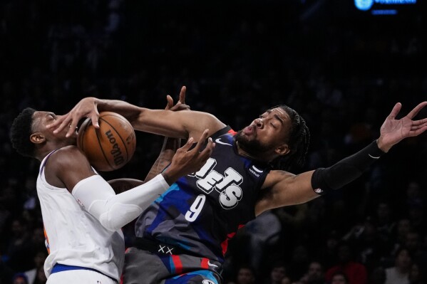 Brooklyn Nets' Trendon Watford defends New York Knicks' RJ Barrett, left, during the first half of an NBA basketball game Wednesday, Dec. 20, 2023, in New York. (AP Photo/Frank Franklin II)