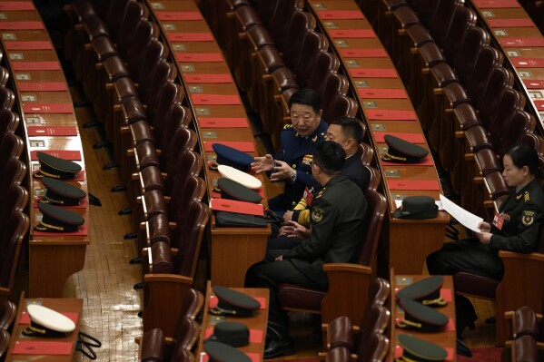FILE - Military delegates chat before the closing session of the National People's Congress at the Great Hall of the People in Beijing, Monday, March 11, 2024. Chinese state media said Thursday, June 13, 2024, that a military history buff found a collection of confidential documents related to the country's military in a pile of old papers he bought for under $1. (AP Photo/Ng Han Guan, File)