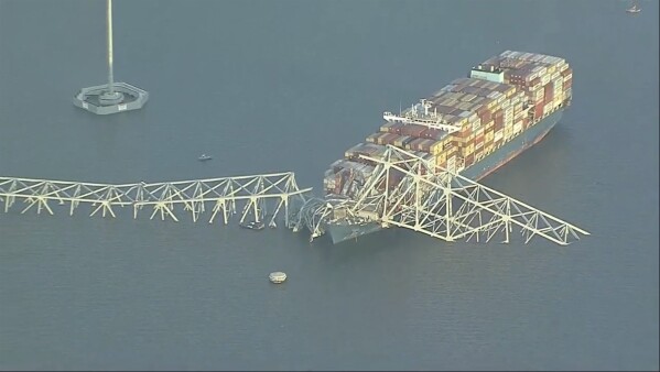 Portions of the Francis Scott Key Bridge remain intact after a container ship collided with a support, Tuesday, March 26, 2024, in Baltimore.  (AP via WJLA)