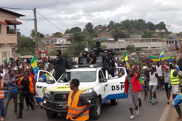 FILE - This video grab shows coup supporters cheering police officers in Libreville, Gabon, on Aug. 30, 2023. Gabon’s opposition leader accused the family of the recently ousted president of engineering his removal from power in order to retain their control in the oil-rich Central African nation. (AP Photo/Betiness Mackosso, File)