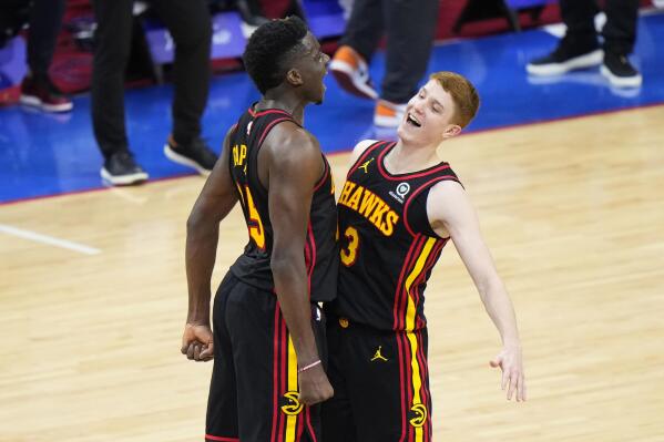 Atlanta Hawks' Kevin Huerter, right, and Clint Capela celebrate during the final seconds of Game 7 in a second-round NBA basketball playoff series against the Philadelphia 76ers, Sunday, June 20, 2021, in Philadelphia. (AP Photo/Matt Slocum)
