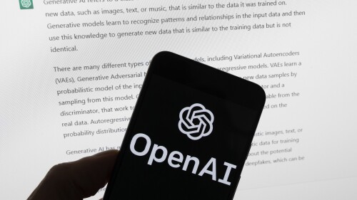 FILE - The OpenAI logo is seen on a mobile phone in front of a computer screen displaying output from ChatGPT, March 21, 2023, in Boston. The U.S. Federal Trade Commission has launched an investigation into ChatGPT creator OpenAI and whether the artificial intelligence company violated consumer protection laws by scraping public data and publishing false information through its chatbot, according to reports in the Washington Post and the New York Times. (AP Photo/Michael Dwyer, File)