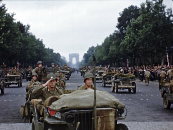 U.S. military vehicles and soldiers march down the Champs-Elysees after the liberation of Paris. Seventy-five years later, surprising color images of the D-Day invasion and aftermath bring an immediacy to wartime memories. They were filmed by Hollywood director George Stevens and rediscovered years after his death.  (War Footage From the George Stevens Collection at the Library of Congress via AP)