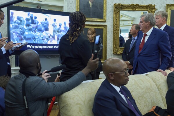 South African businessman Johann Rupert, who is right, looks at a video in Washington during a meeting between President Donald Trump and South African President Cyril Ramaphosa in the Oval Office of the White House on Wednesday, May 21, 2025. (AP Photo/Evan Vucci)