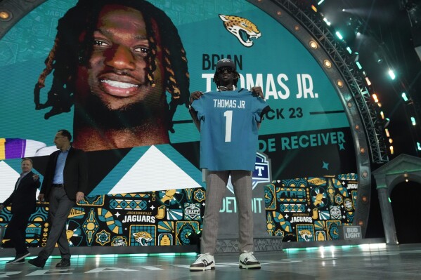 LSU wide receiver Brian Thomas Jr. poses after being chosen by the Jacksonville Jaguars with the 23rd overall pick during the first round of the NFL football draft, Thursday, April 25, 2024, in Detroit. (AP Photo/Jeff Roberson)