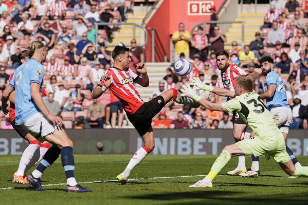 Southampton's Jan Bednarek, center, and goalkeeper Aaron Ramsdale collide trying to defend the ball during a Premier League soccer match between Manchester City and Southampton, at St Mary's Stadium, Southampton, England, Saturday May 10, 2025. (Andrew Matthews/PA via AP)