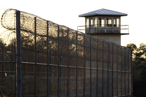The sun sets behind Holman Prison in Atmore, Ala., Jan., 27, 2022. (AP Photo/Jay Reeves, File)