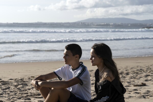 Siblings Sofia Oliveira, 18, and Andre Oliveira, 15, pose for a picture at the beach in Costa da Caparica, south of Lisbon, Wednesday, Sept. 20, 2023. They are two of the six Portuguese children and young adults set to take 32 European governments to court on Wednesday, Sept. 27, for what they say is a failure to adequately address human-caused climate change in a violation of their human rights. (AP Photo/Ana Brigida)