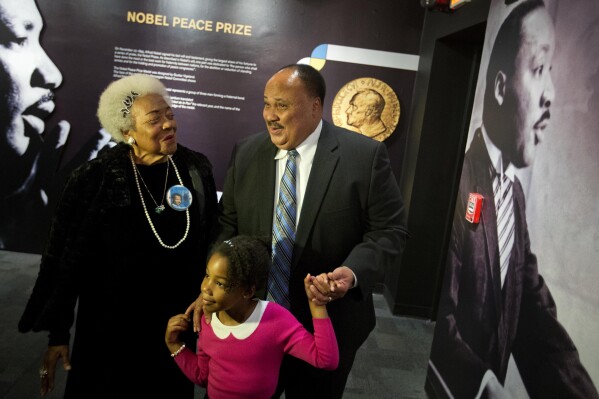 FILE - Martin Luther King III, right, the son of Rev. Martin Luther King Jr., walks with his daughter Yolanda, and Naomi King, left, the wife of Rev. King's brother, A.D., through an exhibition devoted to the awarding of the Nobel Peace Prize to King at the Martin Luther King Jr. Historical Site, Wednesday, Dec. 10, 2014, in Atlanta. Civil rights activist Naomi Barber King died Thursday, March 7, 2024, in Atlanta, according to family members. She was 92. (AP Photo/David Goldman, File)
