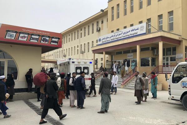 People stand outside a hospital after a bomb blast in Mazar-e Sharif, the capital city of Balkh province, in northern Afghanistan, Thursday, March 9, 2023. A bomb killed a Taliban-appointed provincial governor and two others in Afghanistan's Mazar-e- Sharif Thursday, a Taliban police spokesman said. (AP Photo/Abdul Saboor Sirat)