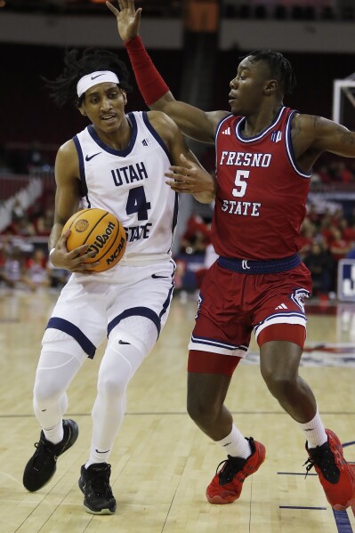 Ian Martínez, de Utah State, intenta pasar a Jalen Weaver, de Fresno State, durante la primera mitad de un partido de baloncesto universitario de la NCAA en Fresno, California, el martes 27 de febrero de 2024. (Foto AP/Gary Kazanjian)