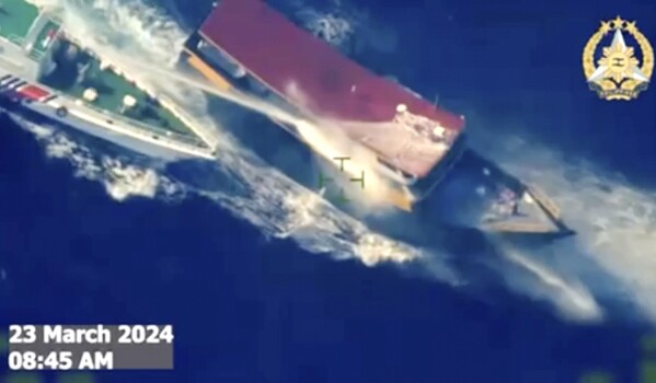 In this screen grab from video provided by the Armed Forces of the Philippines, a Chinese coast guard ship uses water cannons and closely maneuvers beside a Philippine resupply vessel Unaizah May 4 as it approaches Second Thomas Shoal, locally called Ayungin shoal, at the disputed South China Sea on Saturday, March 23, 2024. (Armed Forces of the Philippines via AP)